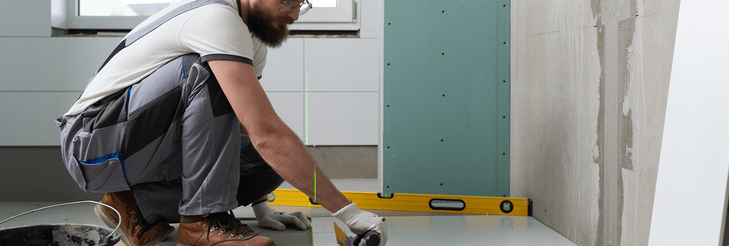 Instalación de Pisos: Trabajador instalando un piso de madera.